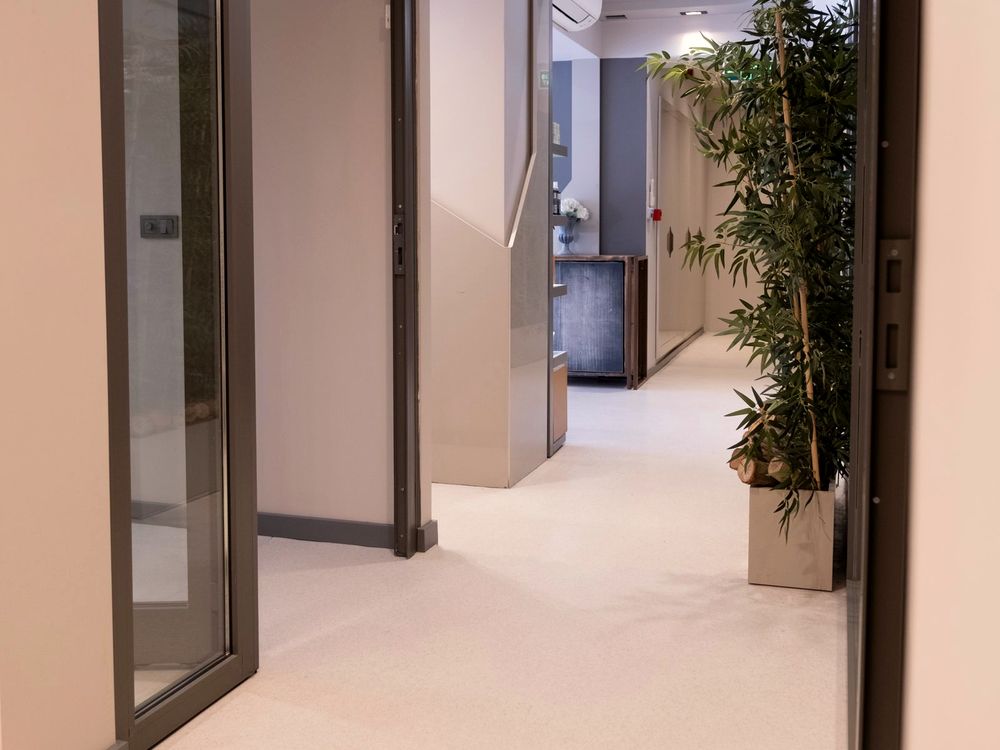 Clean modern clinic corridor with a full-height glass door and bright, hygienic finishes