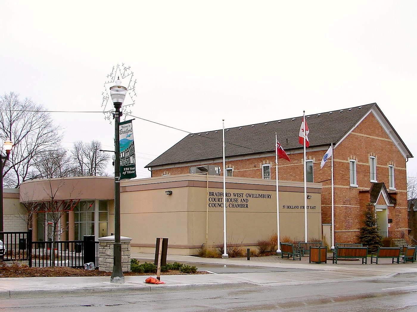 The heritage brick town hall and courthouse in downtown Bradford with flags and a street lamp