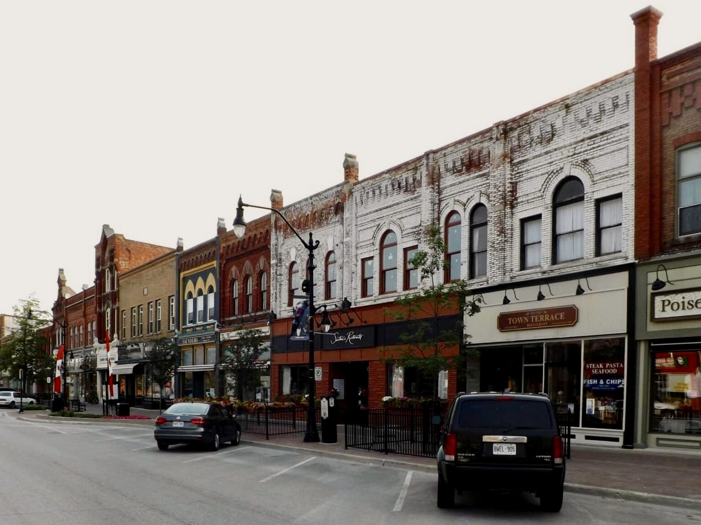 A row of restored heritage storefronts on Hurontario Street in downtown Collingwood on a summer morning