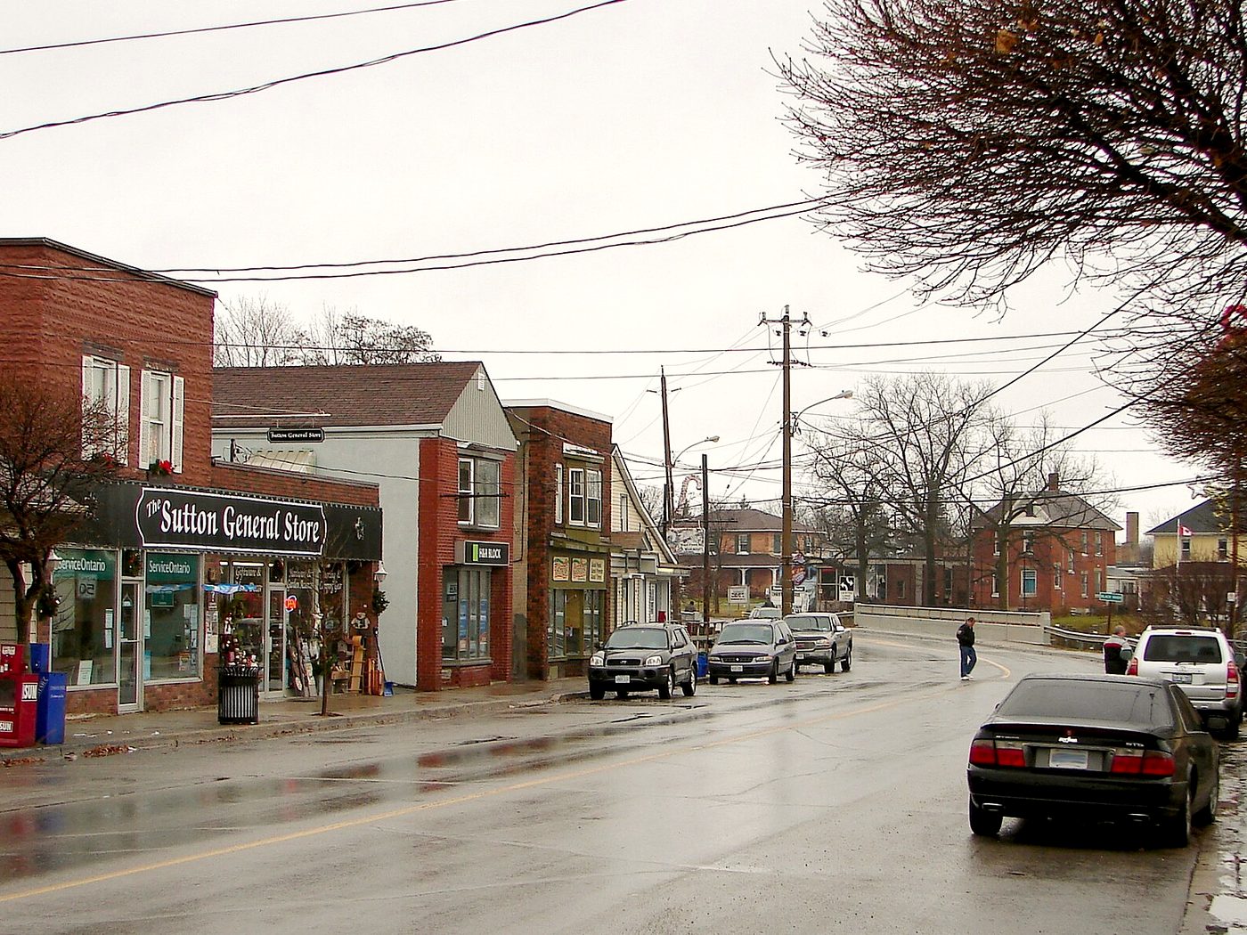 High Street in downtown Sutton, Georgina, with the Sutton General Store and brick storefronts on a wet day